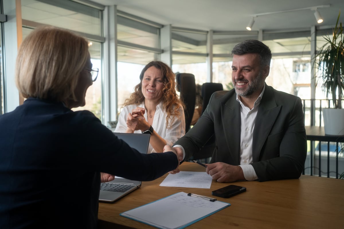 A young couple reaching an agreement with their financial advisor in the office